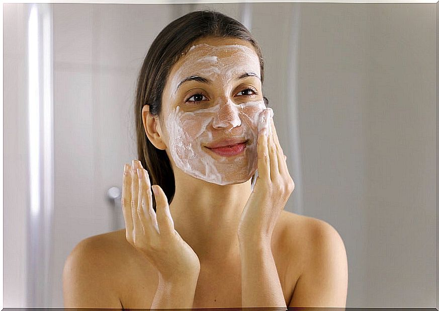 Woman washing her face to remove acne.