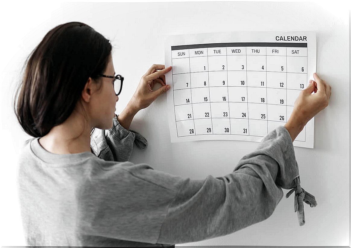 Woman placing a calendar on the wall