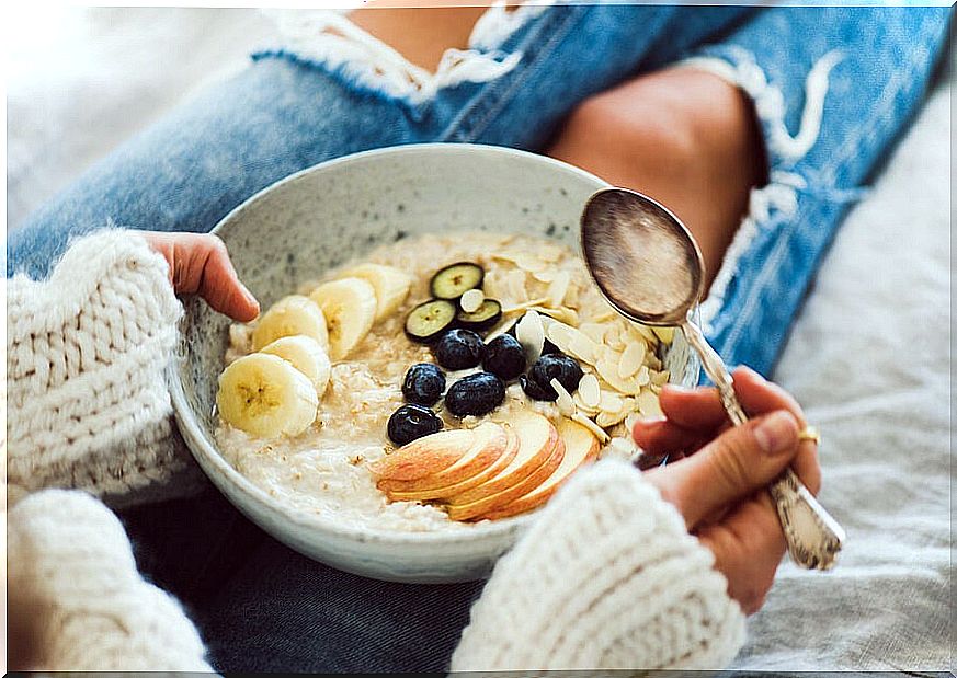 Woman with plate of bircher muesli in winter.