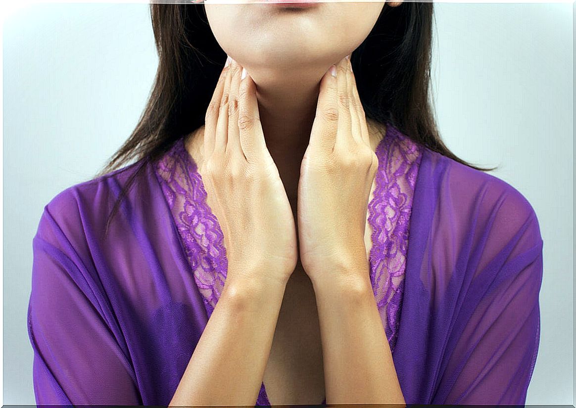 Woman touches her thyroid on the neck