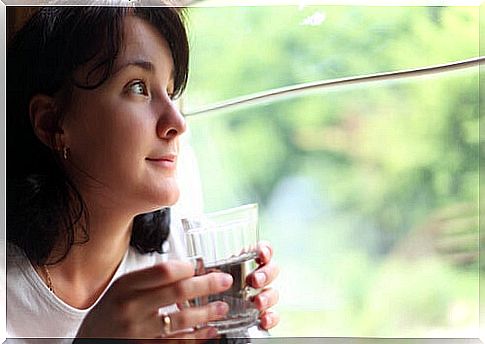 Woman drinking water at a window